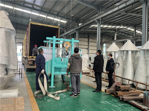 Worker monitoring corn milling machine during operation